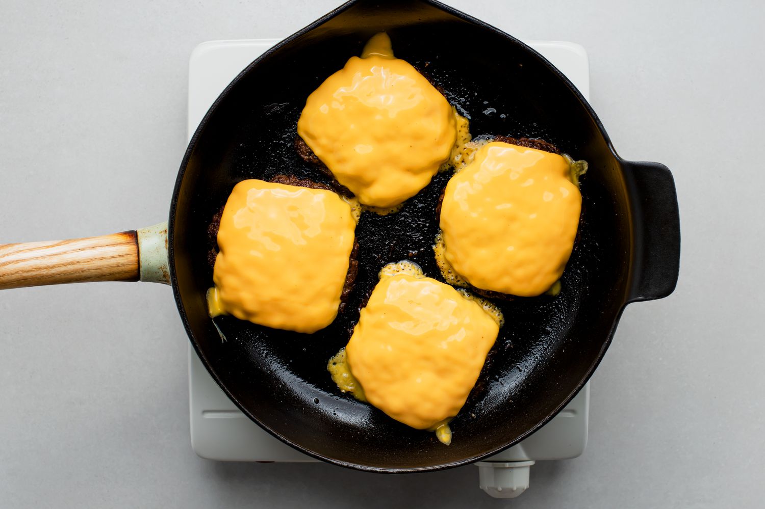 beef patties with cheese in a frying pan 