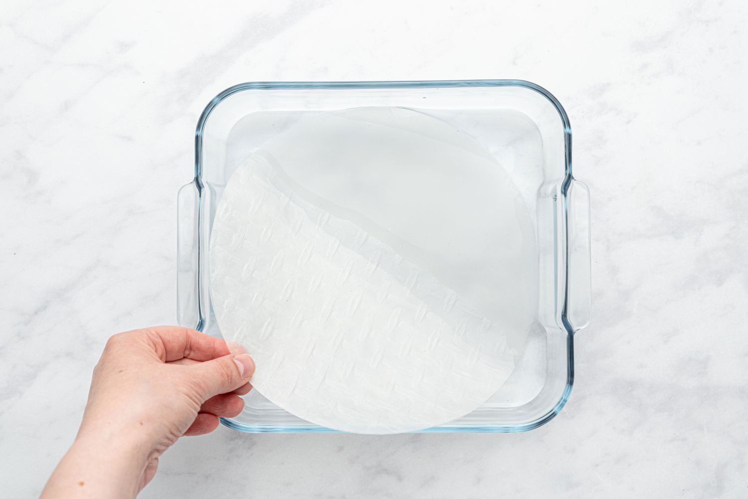 dip rice paper into a baking dish with water 