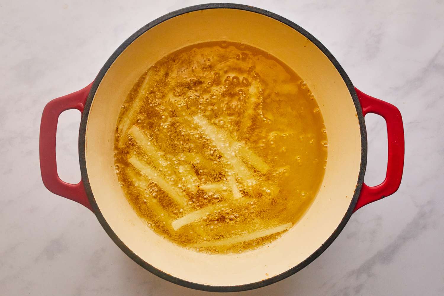 Par-cooking fries in a pot of oil