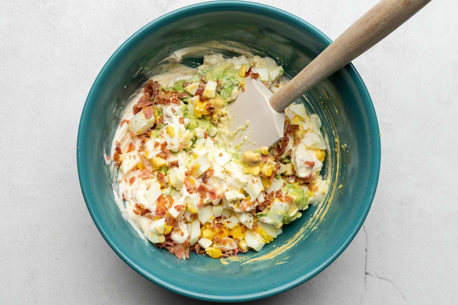 egg salad mixed together with a spatula 