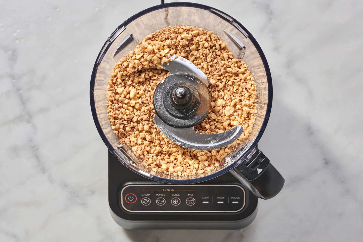 A food processor with coarse crumbs made from butter and the flour-brown sugar mixture