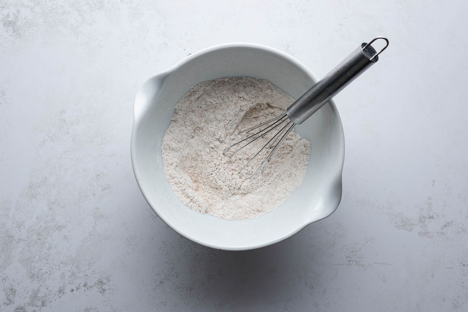 Rice flour, yeast, sugar, and salt in a bowl with a whisk 