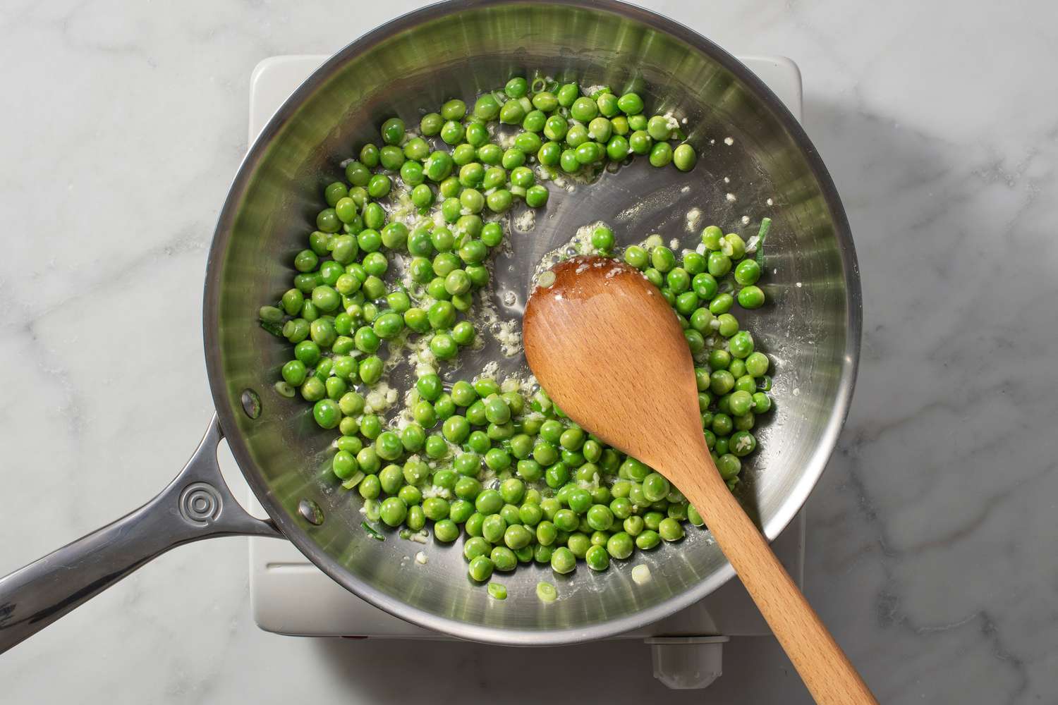 Peas, garlic, and scallions cooking in olive oil and butter