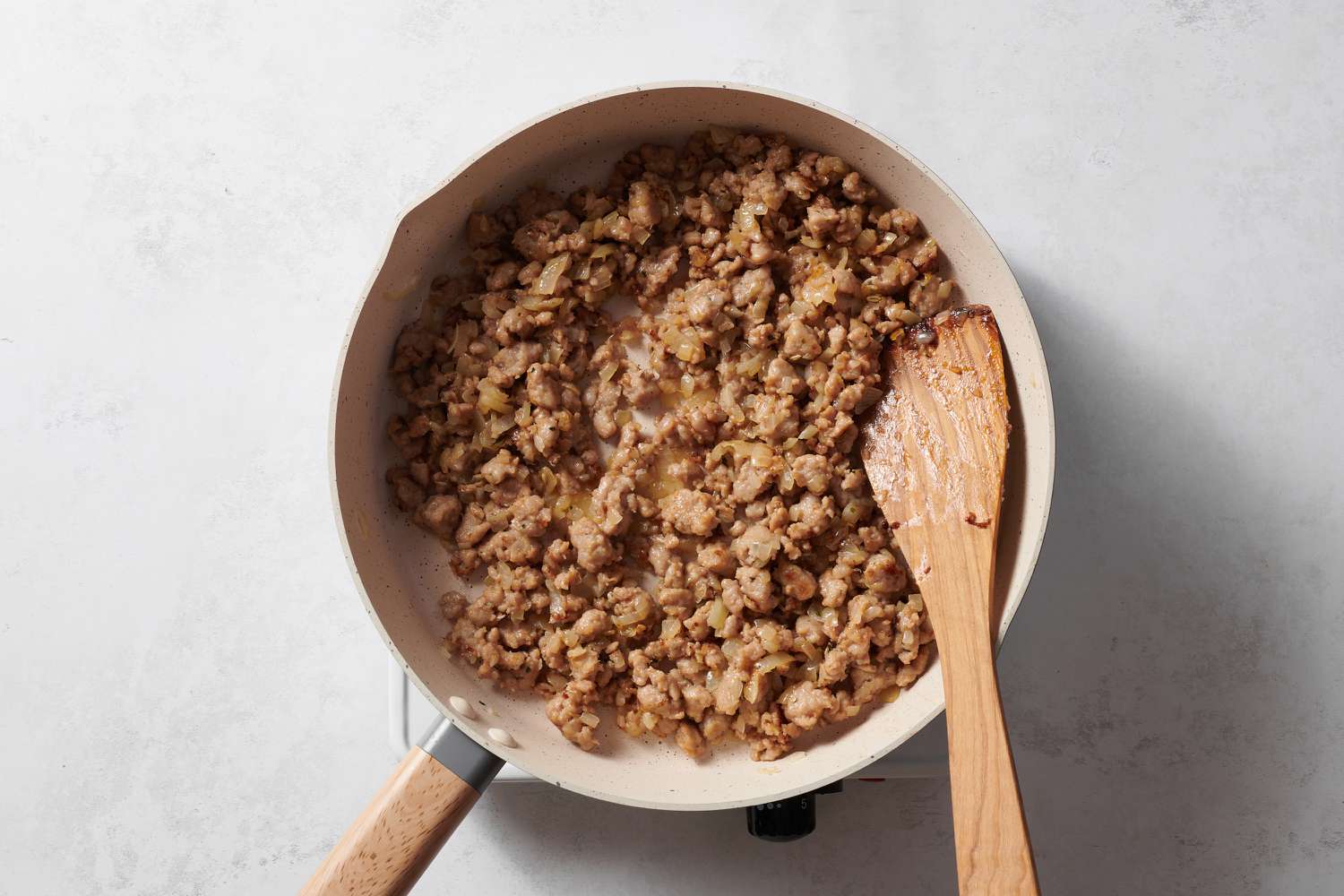 Italian sausage and onions cooking in a pan