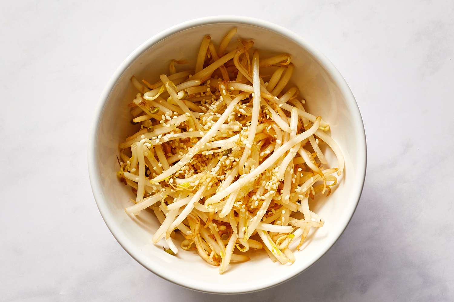 Season bean sprouts with sesame oil, salt, and a dash of sesame seeds