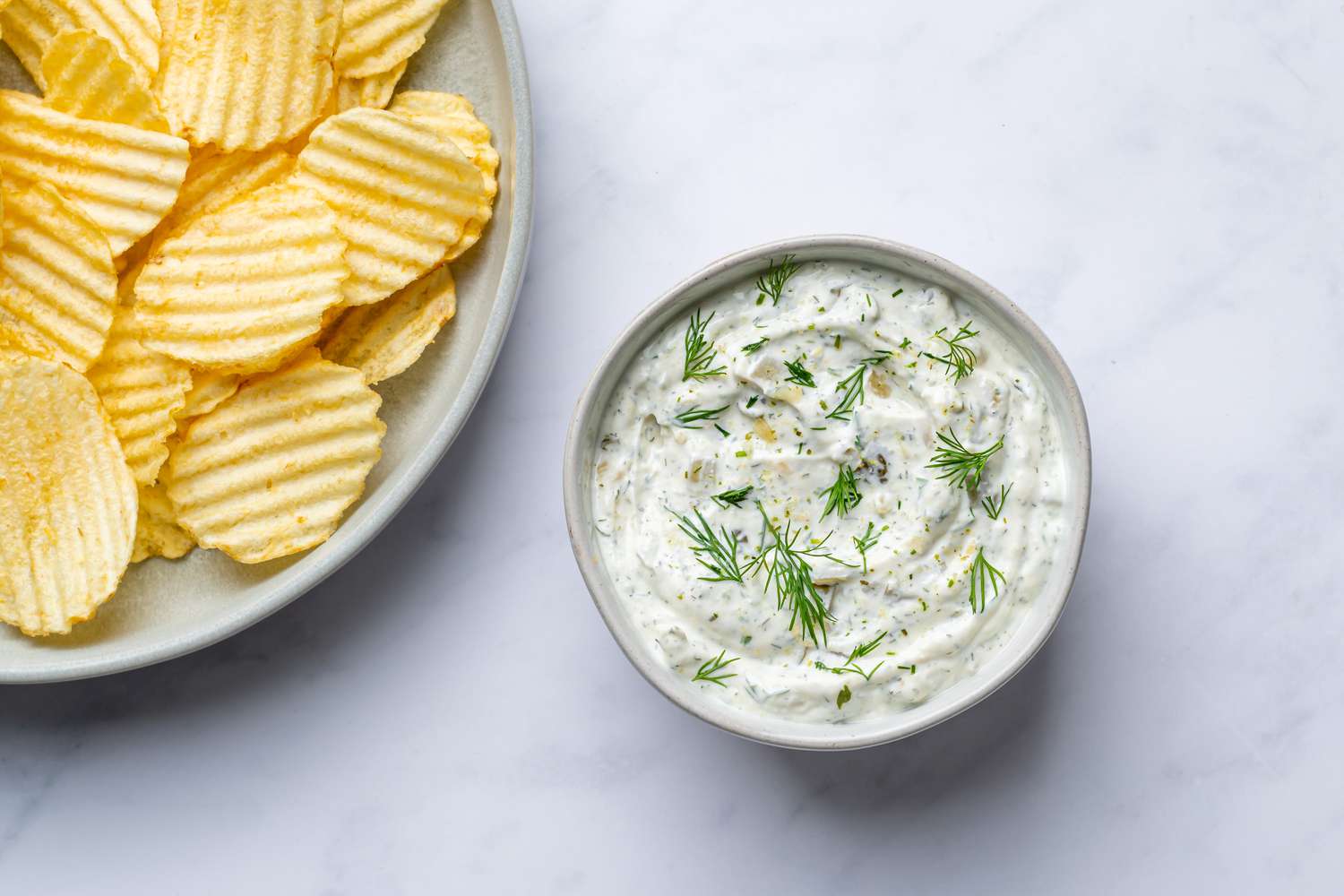 dill pickle dip in a bowl with ruffle potato chips