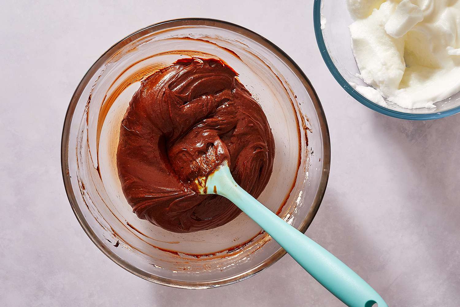 Egg whites folded into the chocolate mixture in the bowl, with a spatula 
