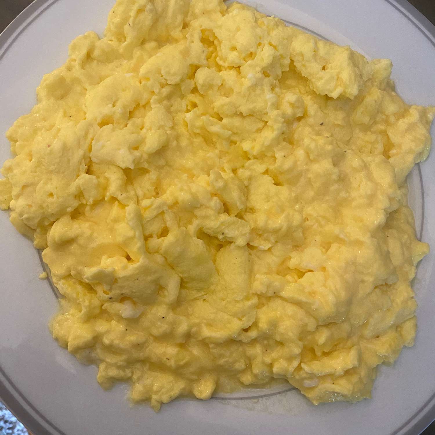Perfect fluffy scrambled eggs on a white plate