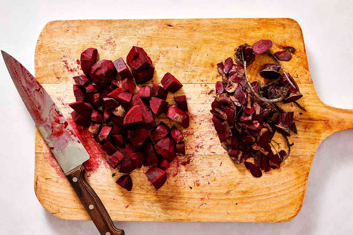 Peeled and diced beets on a cutting board with a knife 