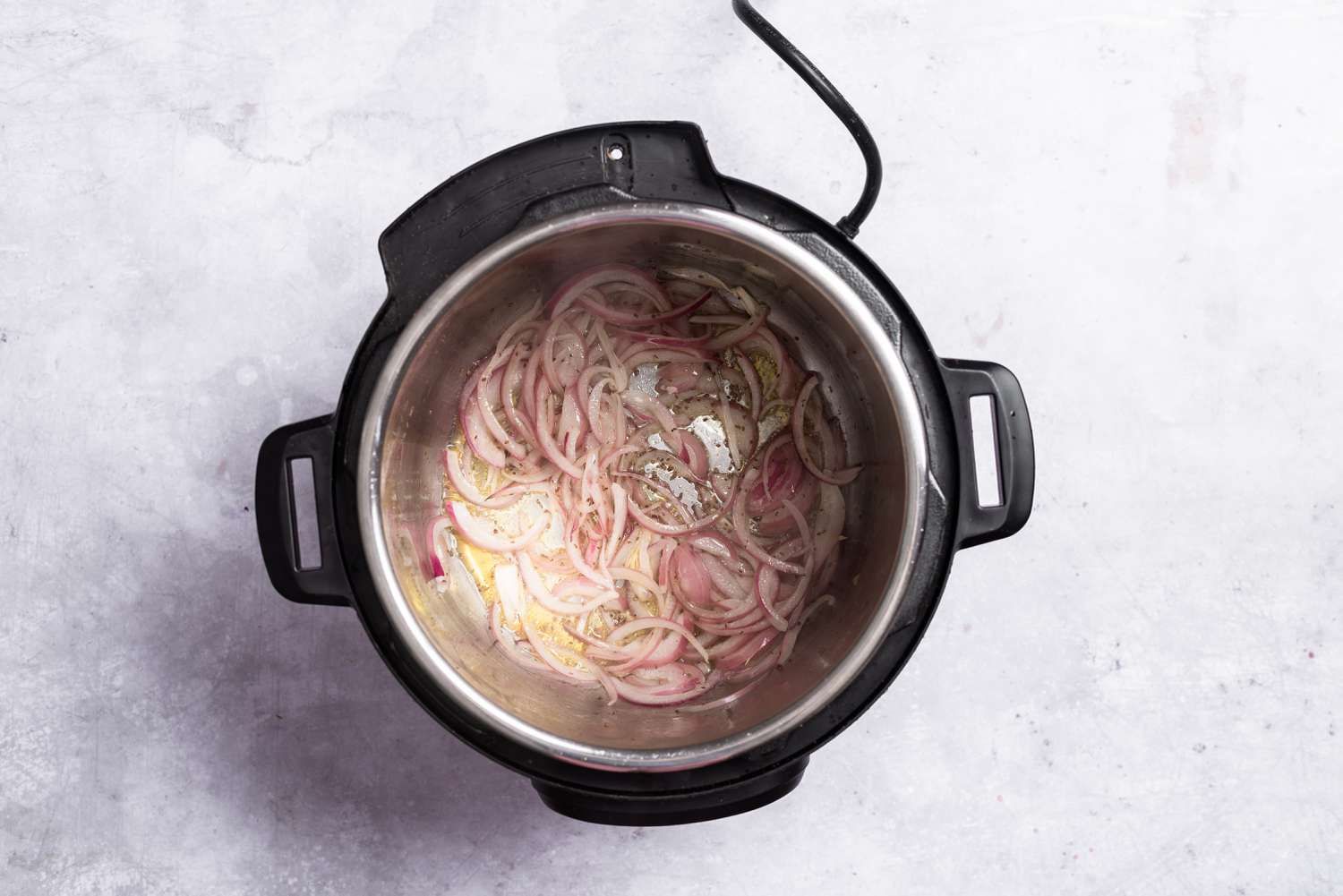 Onions and caraway seeds cooking in an Instant Pot on SAUTE