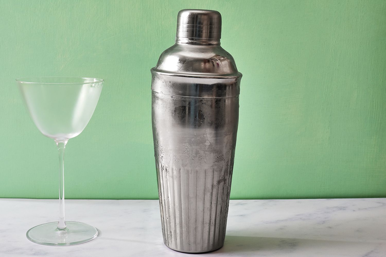 close up view of a cocktail shaker and a glass 