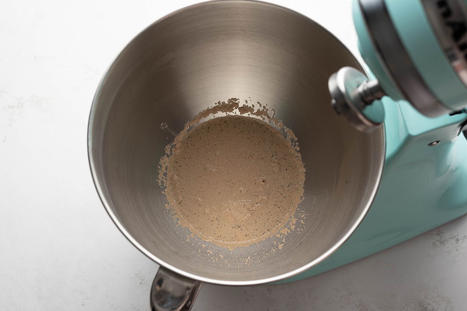 Water, sugar and yeast in a stand mixer 