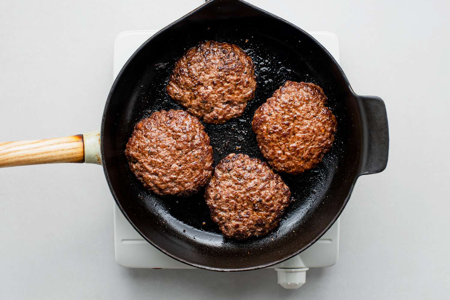 beef patties in a frying pan 