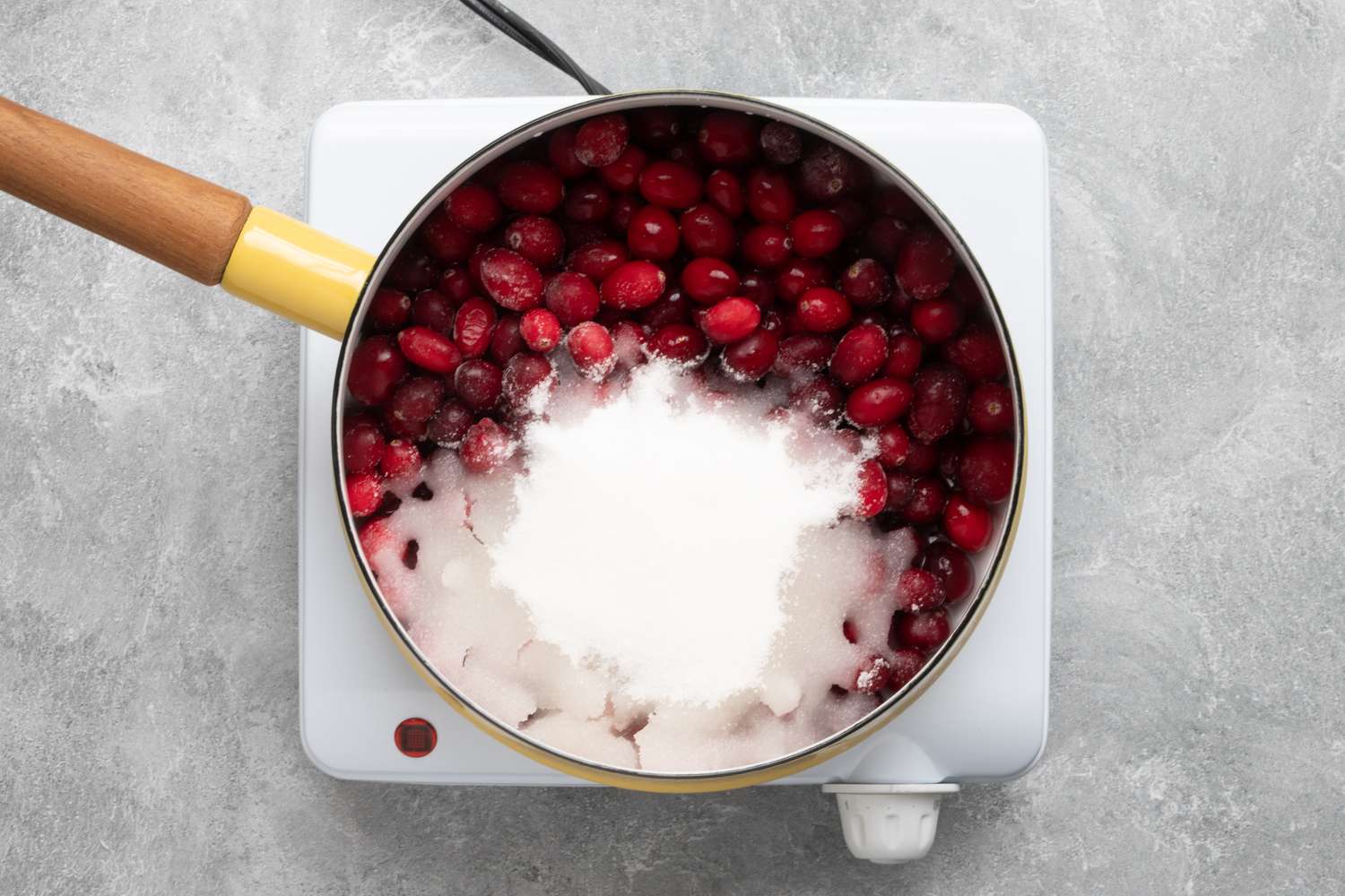 cranberries, sugar, and water are combined in a saucepan