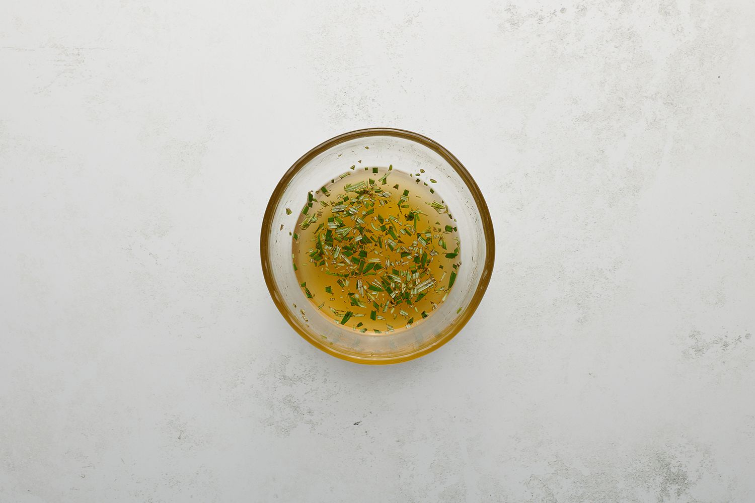 Honey, rum, lime juice, and rosemary in a bowl
