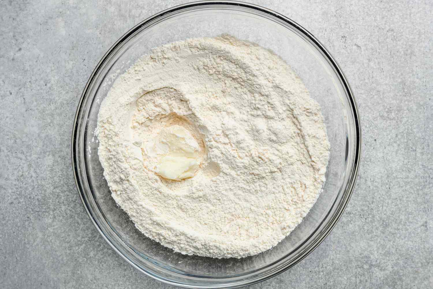 A large bowl with flour, baking powder, salt, and lard