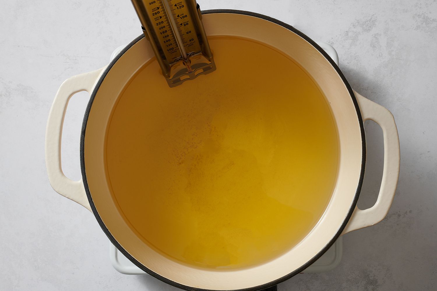 A dutch oven with oil and a thermometer