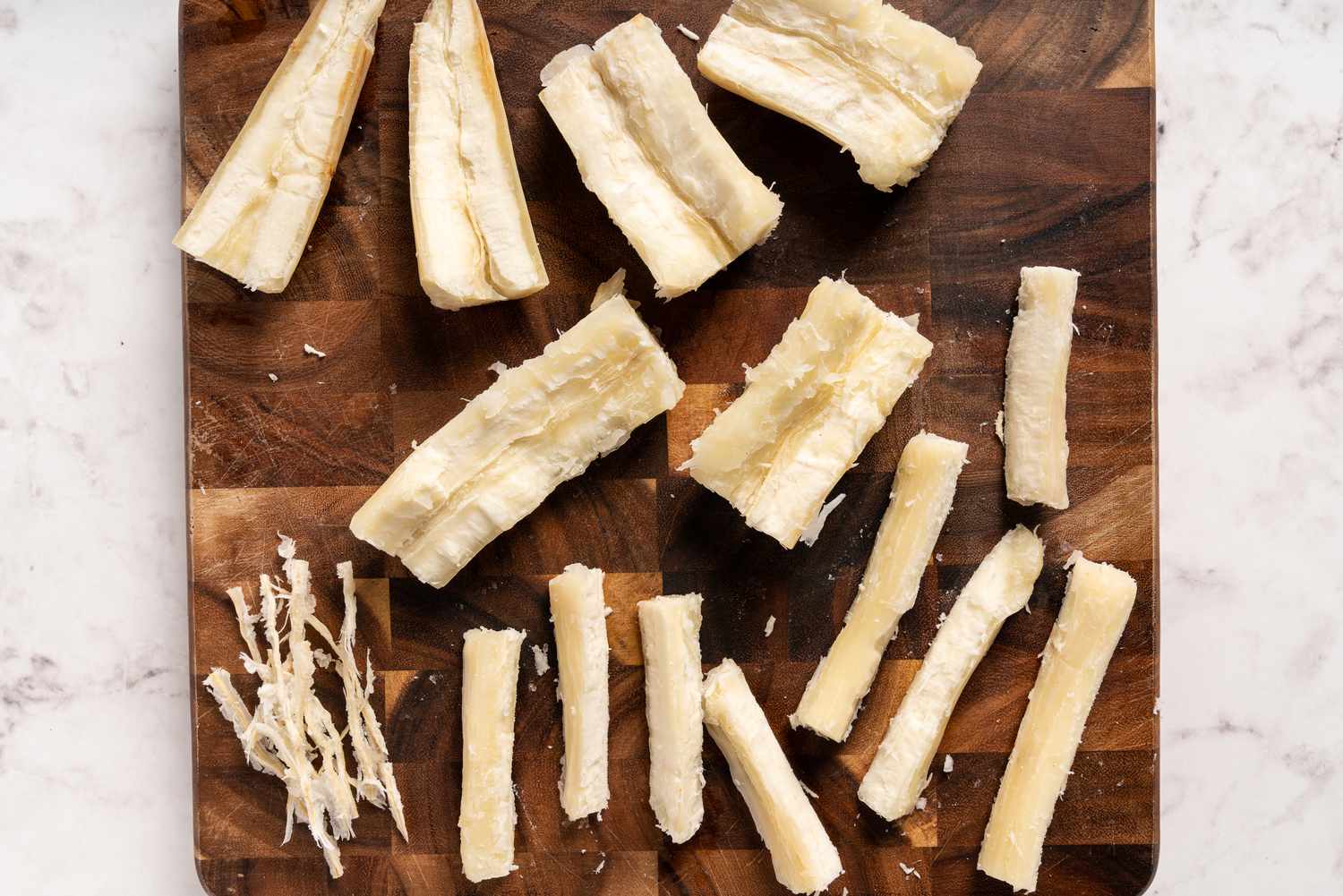 Cassava pieces cut in half and with their hard spine in the middle removed