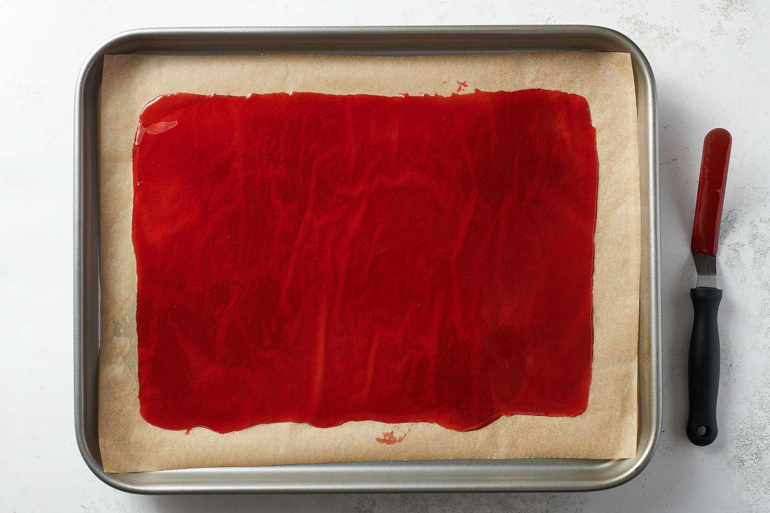 fruit rollup mixture on a parchment lined sheet pan