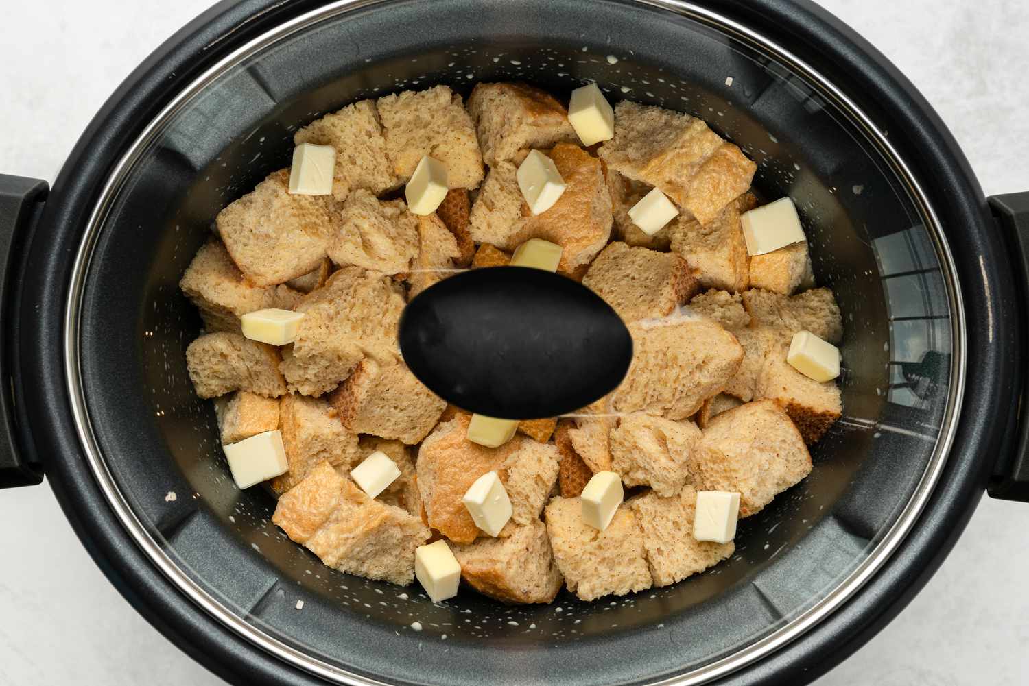 Crock pot French toast cooking with butter cubes