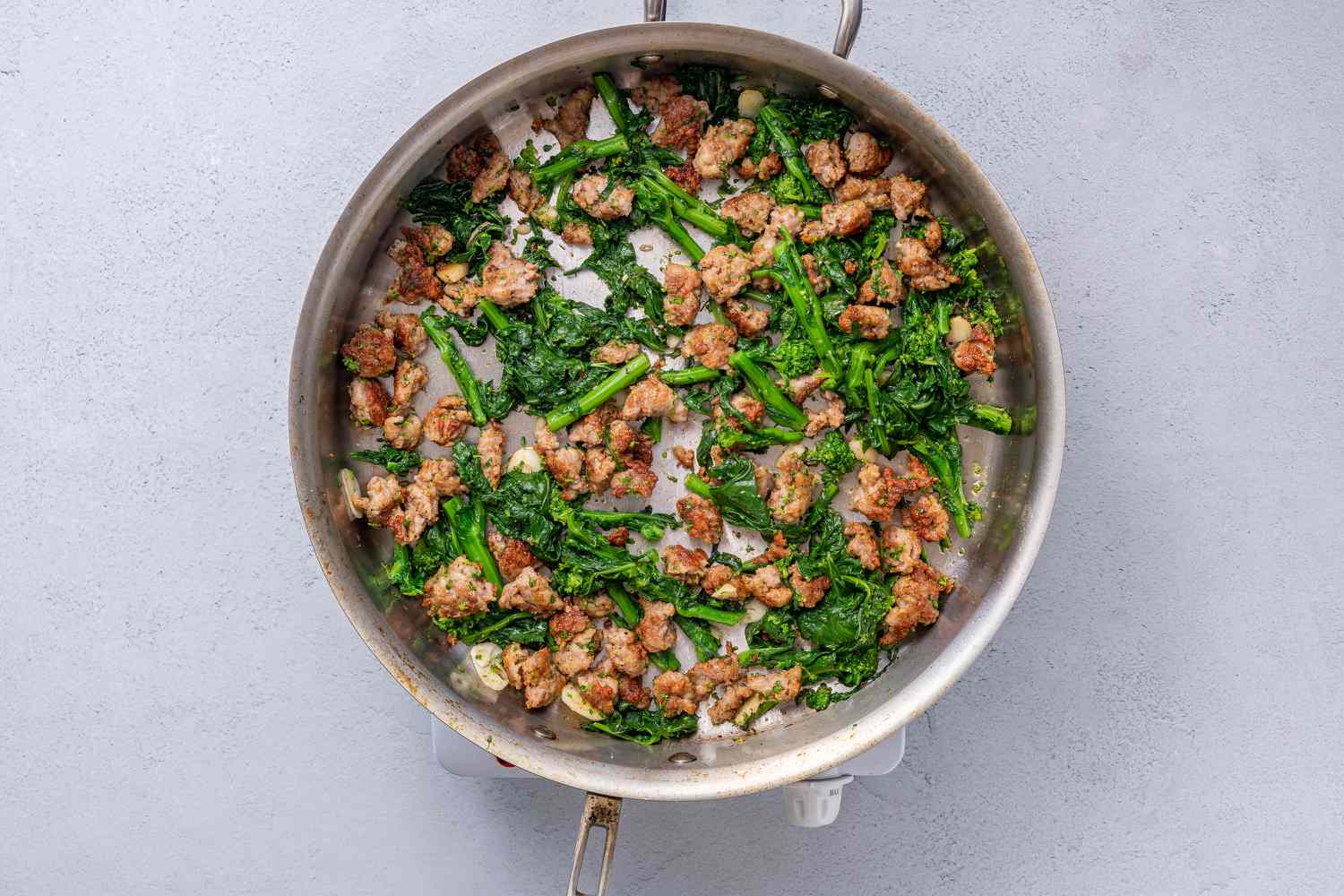 Broccoli rabe added to the pan with sausage