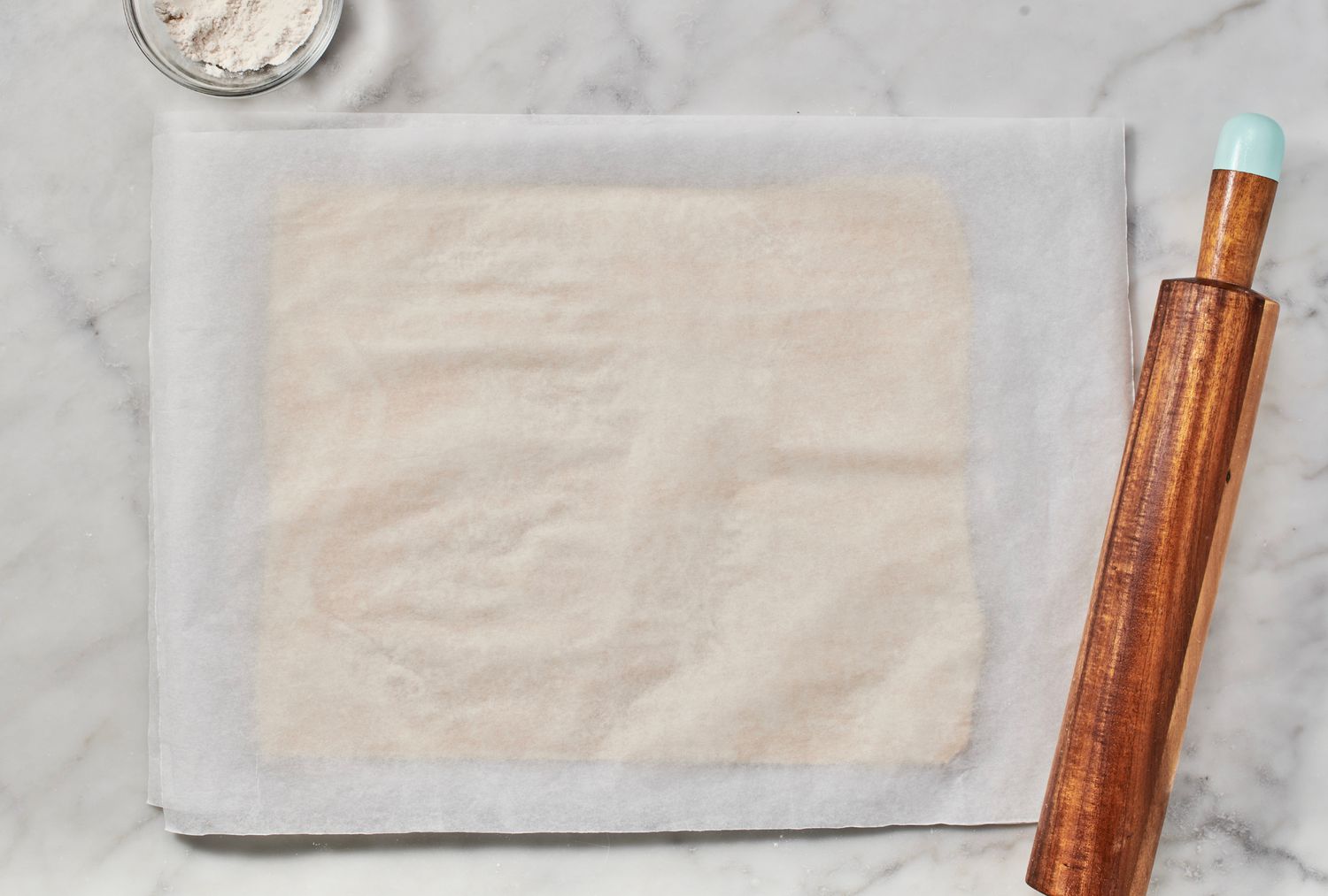 A large, rectangular sheet of puff pastry on parchment paper