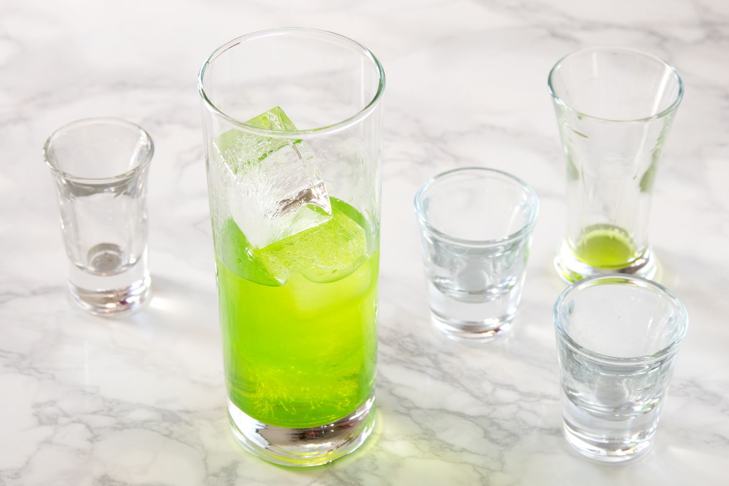 collins glass filled with ice and midori sour ingredients