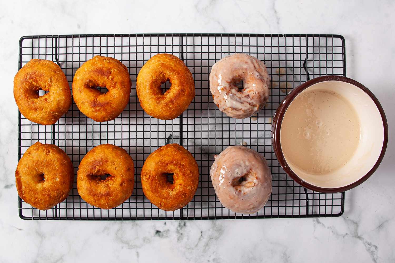Doughnuts dipped in maple glaze on a cooling rack