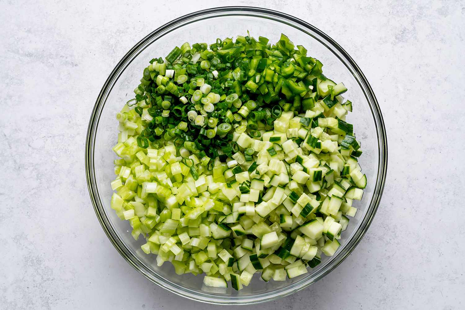 Diced celery, cucumbers, peppers, and green onions added to the cabbage