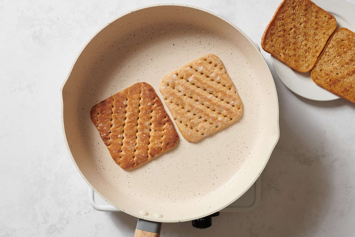 Two slices of bread toasting in a skillet
