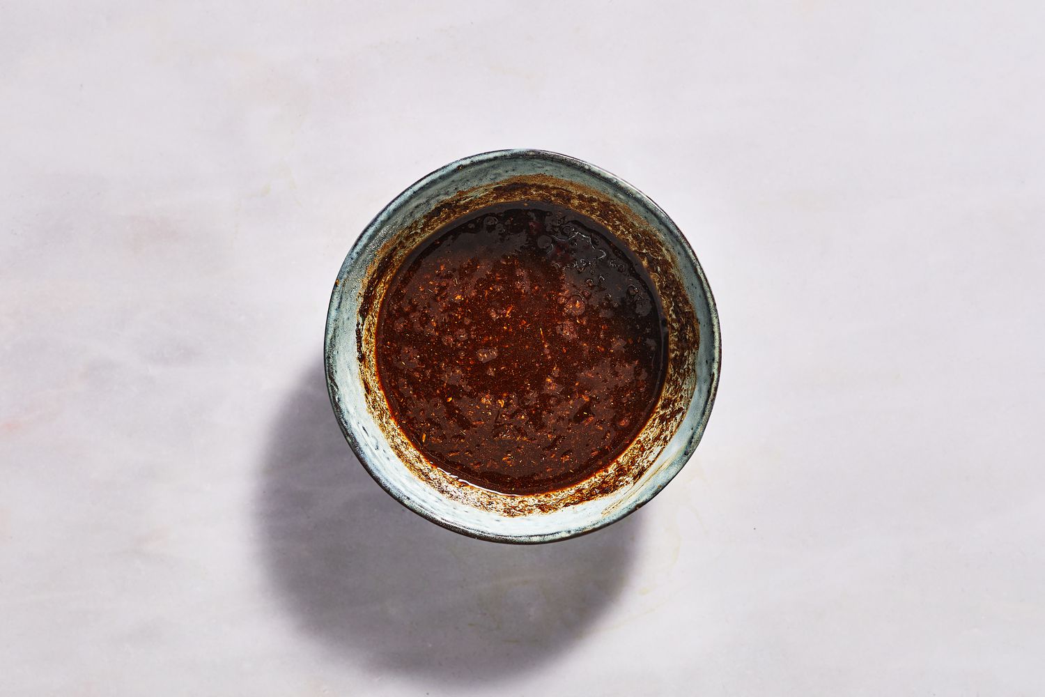 A small bowl with a paste made from cinnamon, salt, cumin, pepper, ginger, and oil