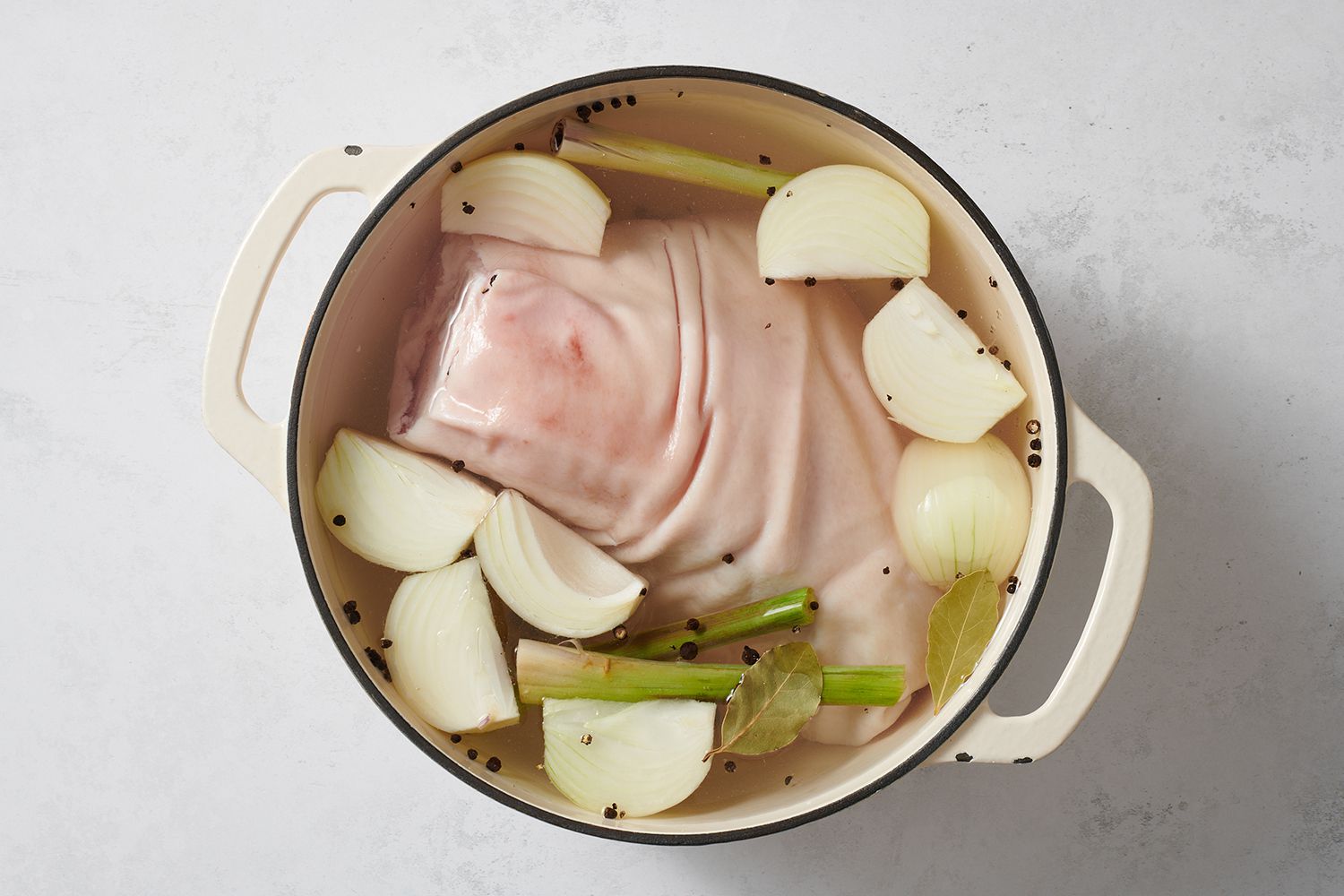 Ham hock, lemongrass, onions, garlic, peppercorns, bay leaves, salt, and water in a dutch oven