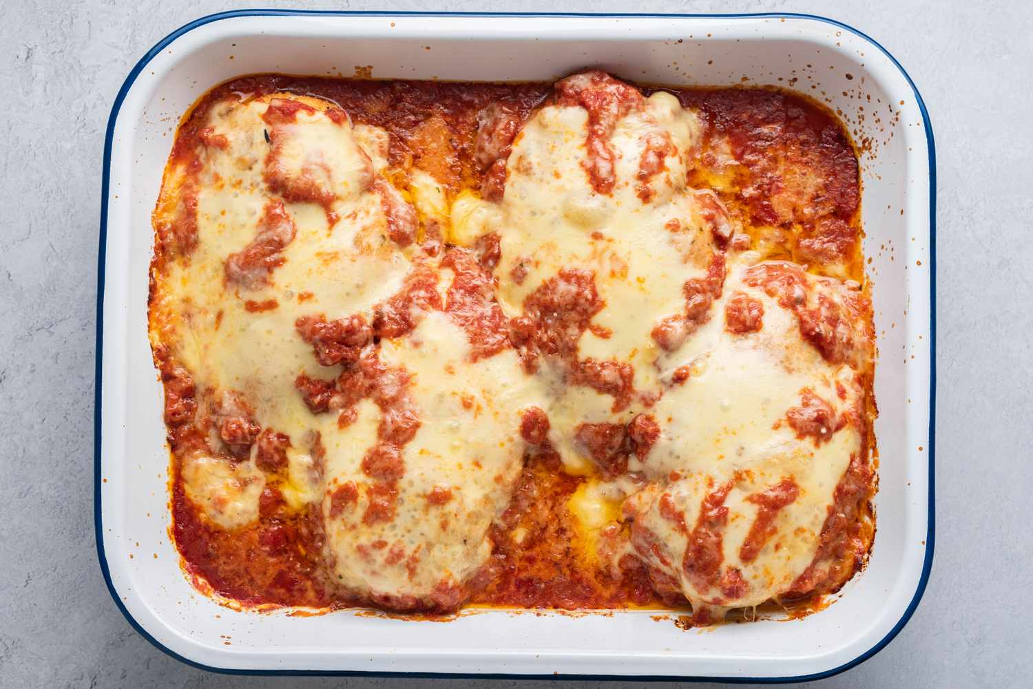 Tomato sauce, chicken and cheese baked in a baking pan