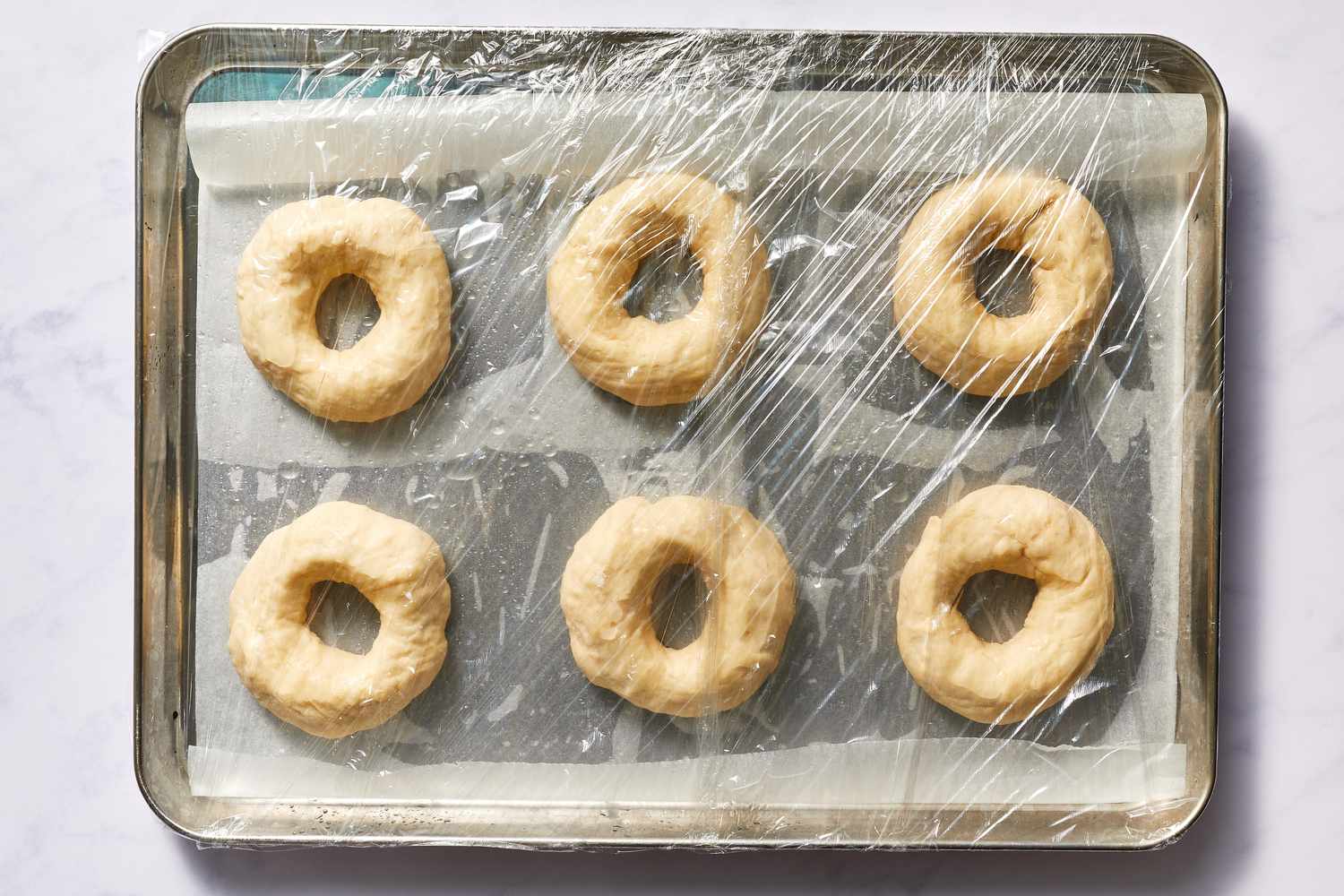 Place the bagels on the parchment and cover them with plastic wrap