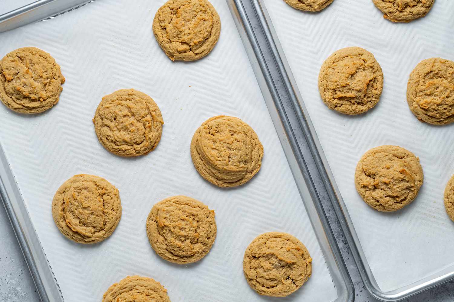 Soft and Chewy Peanut Butter Cookies on lined baking sheets 