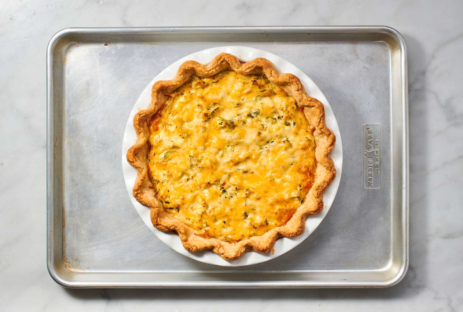 A baked coronation quiche on a baking sheet