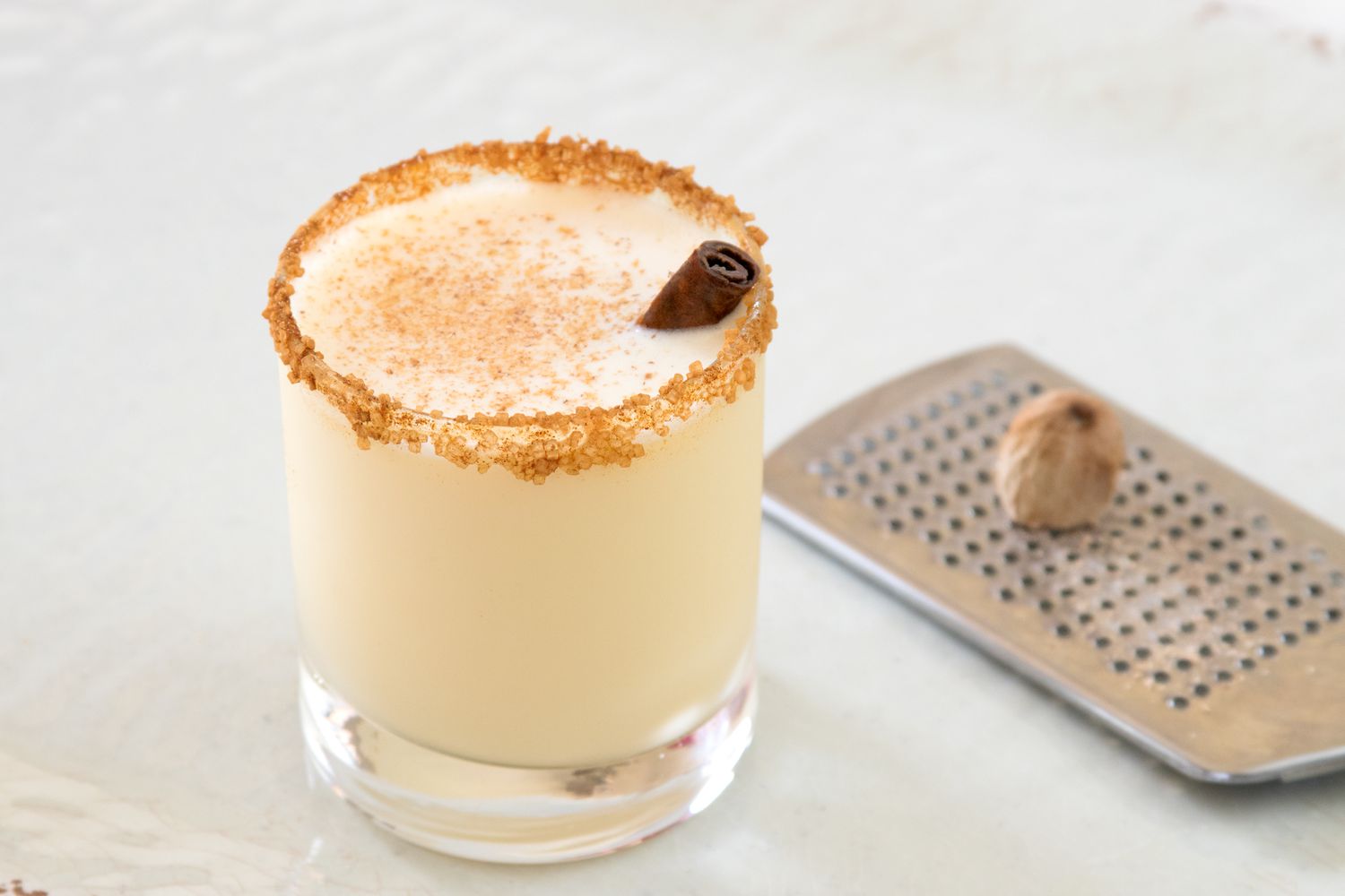 Fireball eggnog cocktail with grater and nutmeg alongside