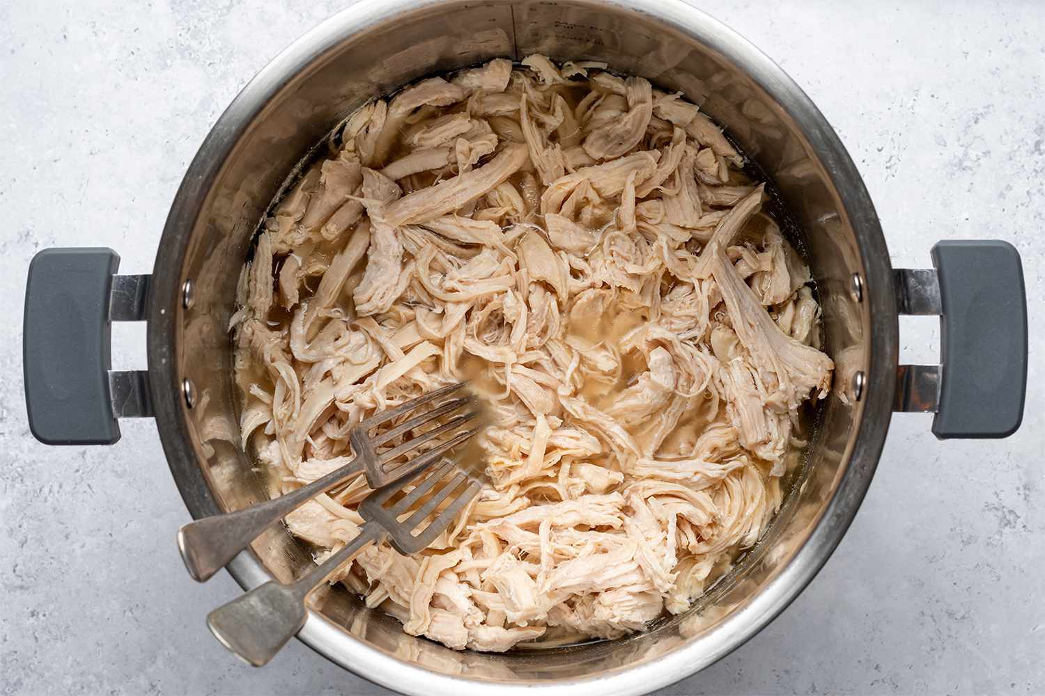 Two forks shredding chicken in an Instant Pot