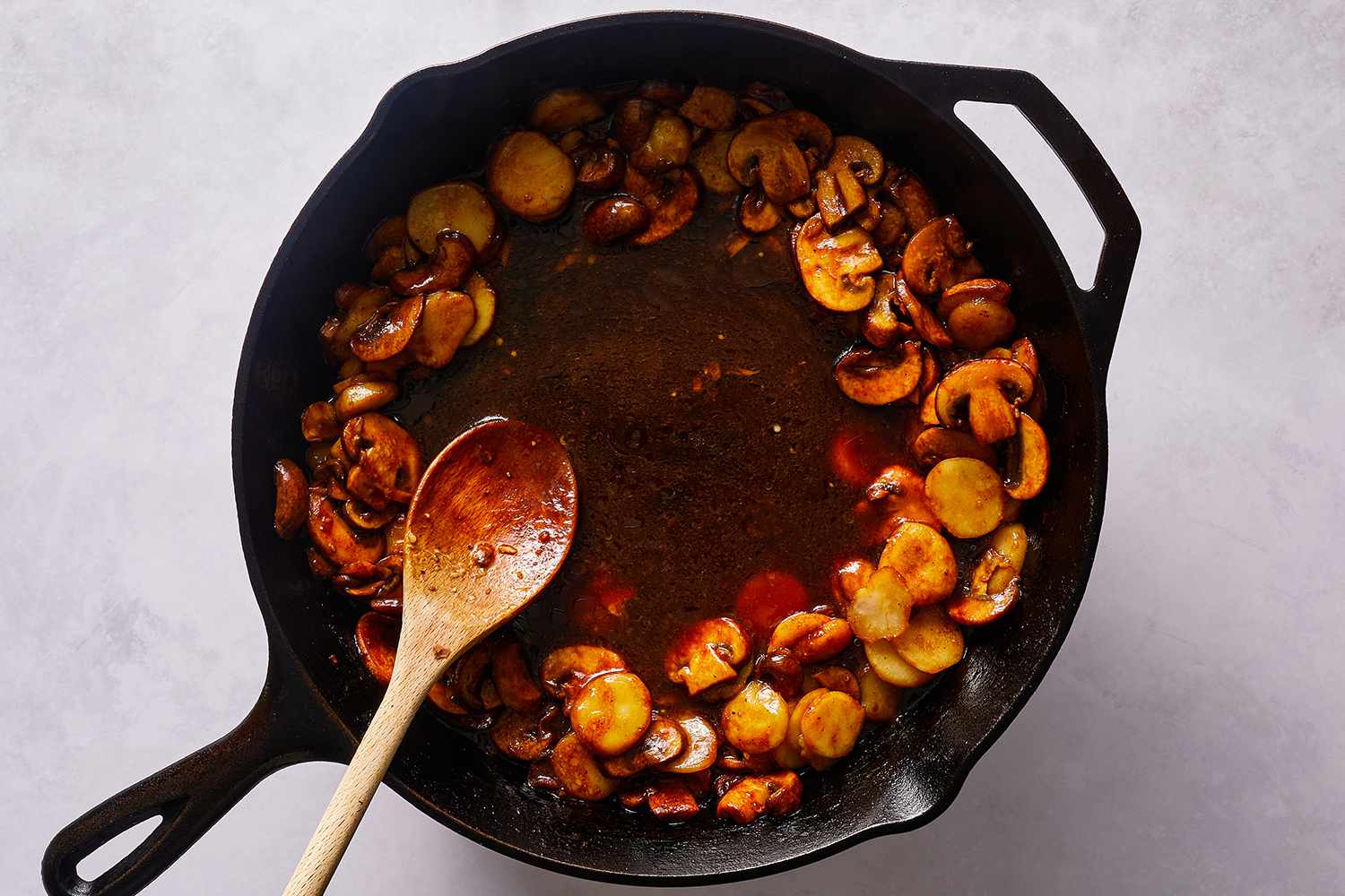 Mater chestnuts, mushrooms and sauce in a cast iron skillet, with a wooden spoon 