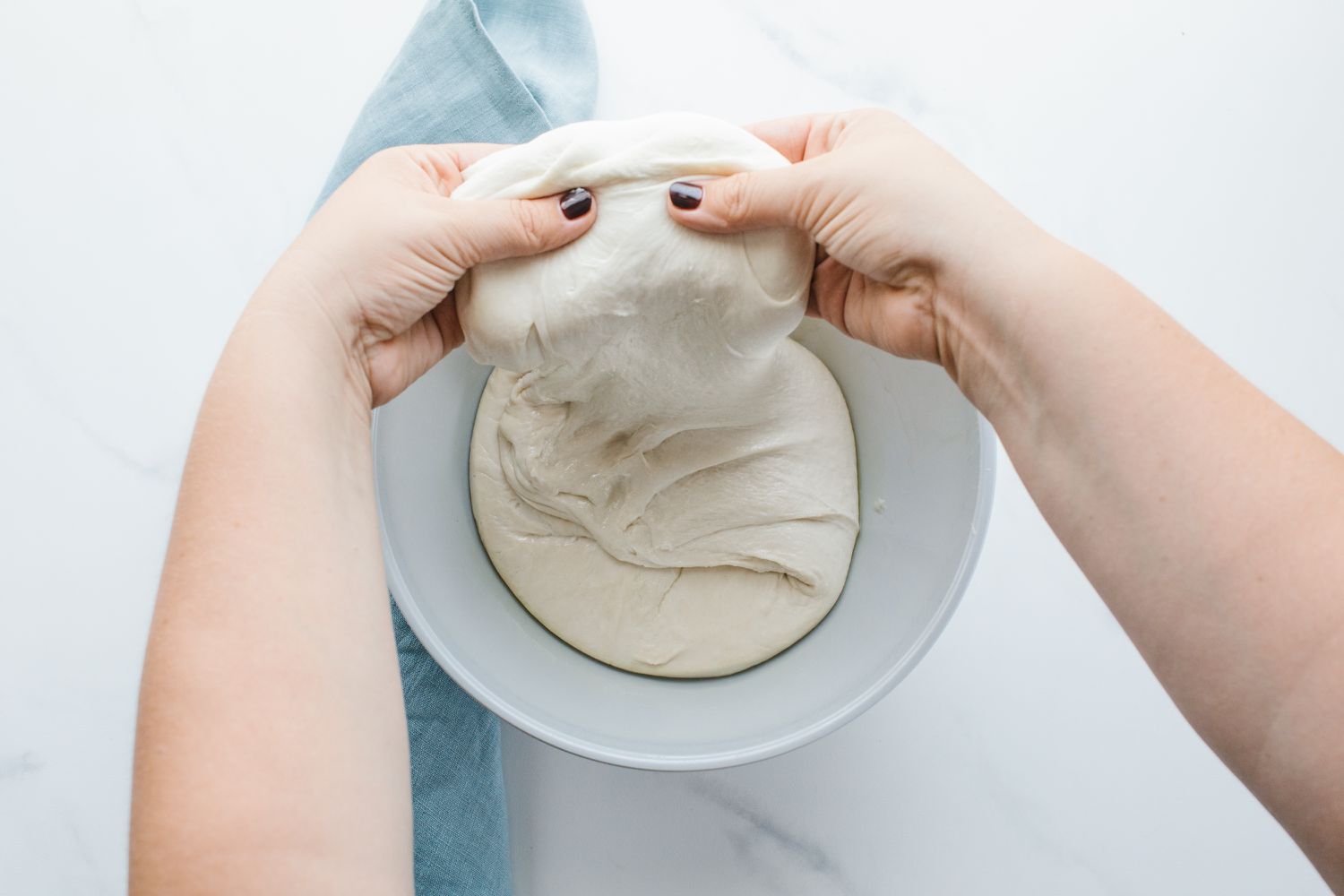 pretzel dough being folded in a bowl