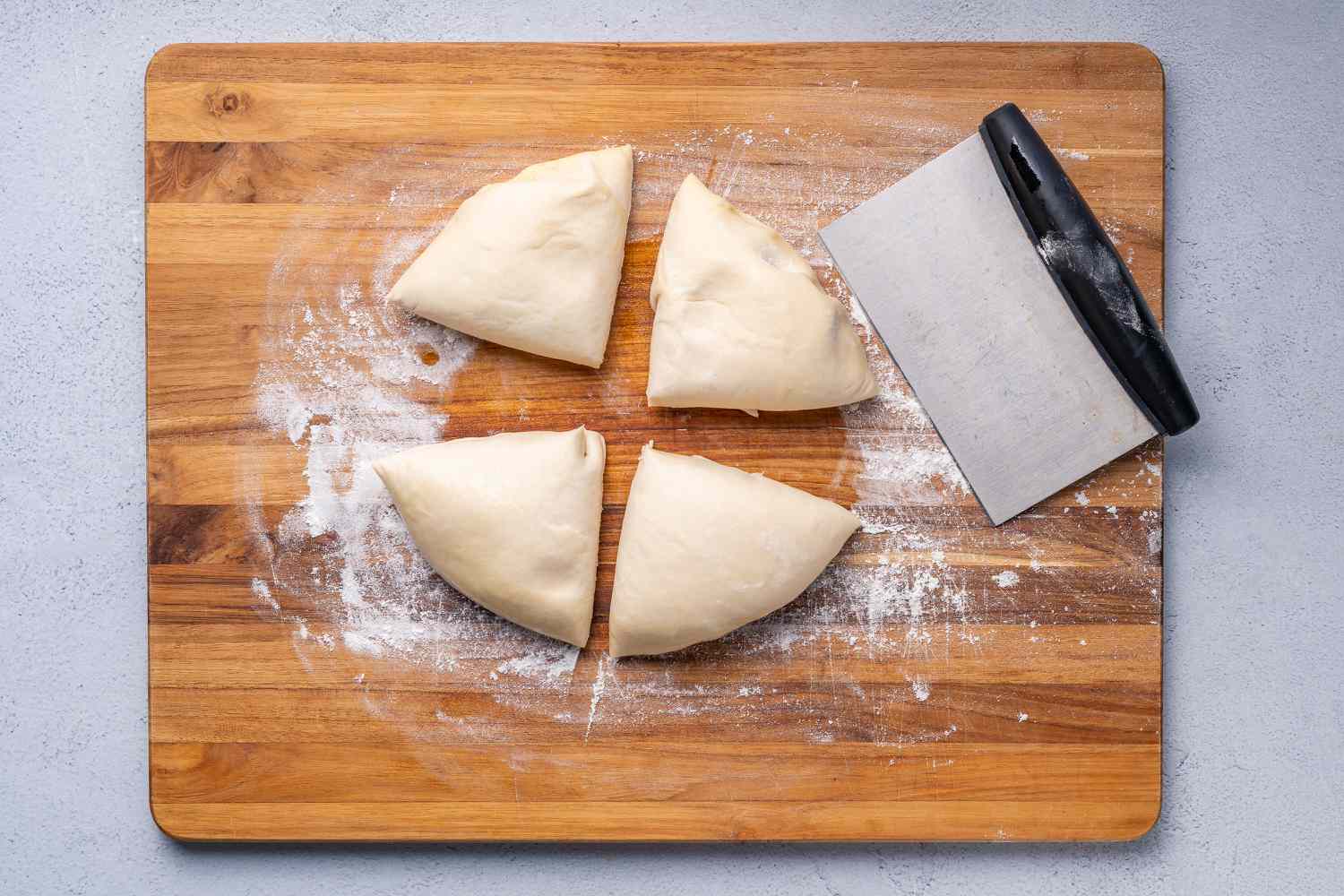 Four pieces of dough on a floured cutting board