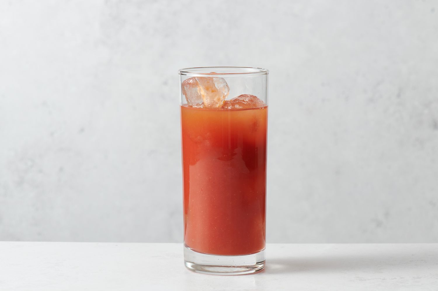 A highball glass with ice, vodka, tomato juice, lemon juice, and Worcestershire sauce