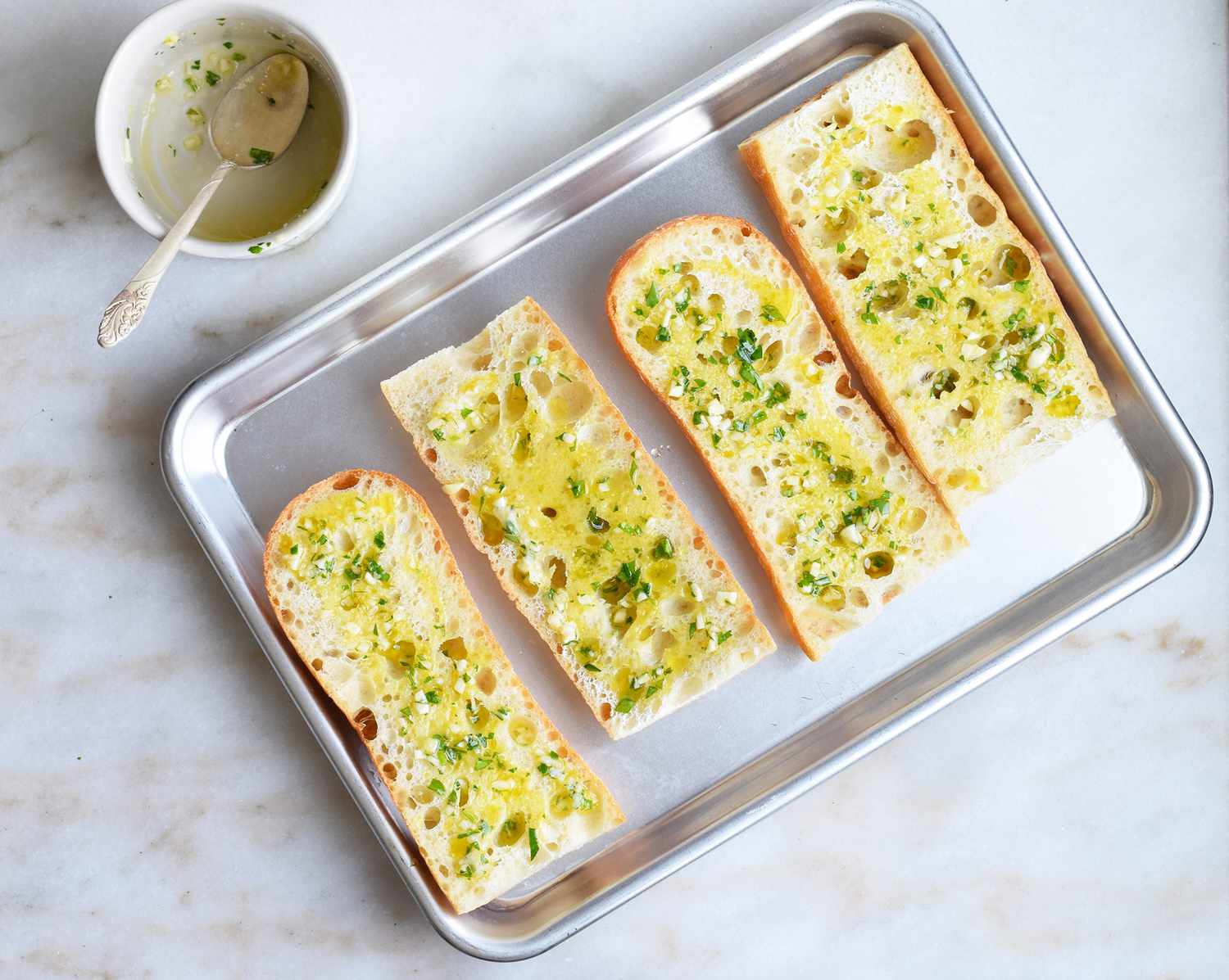 french bread halves covered in garlic butter on a small pan