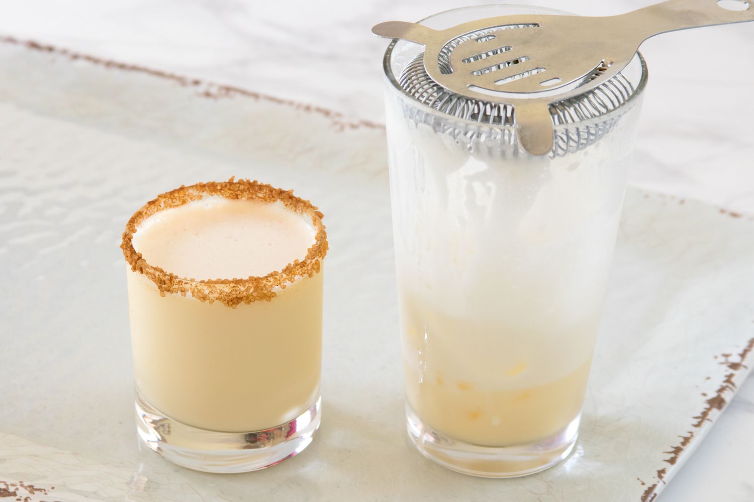 Fireball eggnog cocktail strained into a glass rimmed with sugar and cinnamon