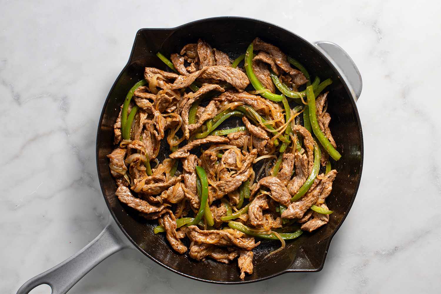 Steak with peppers and onions in a pan 