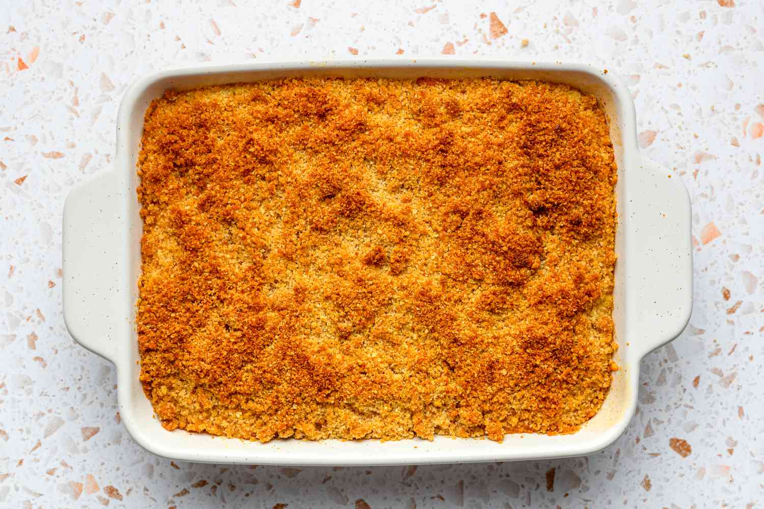 A baked yellow squash casserole in a baking dish