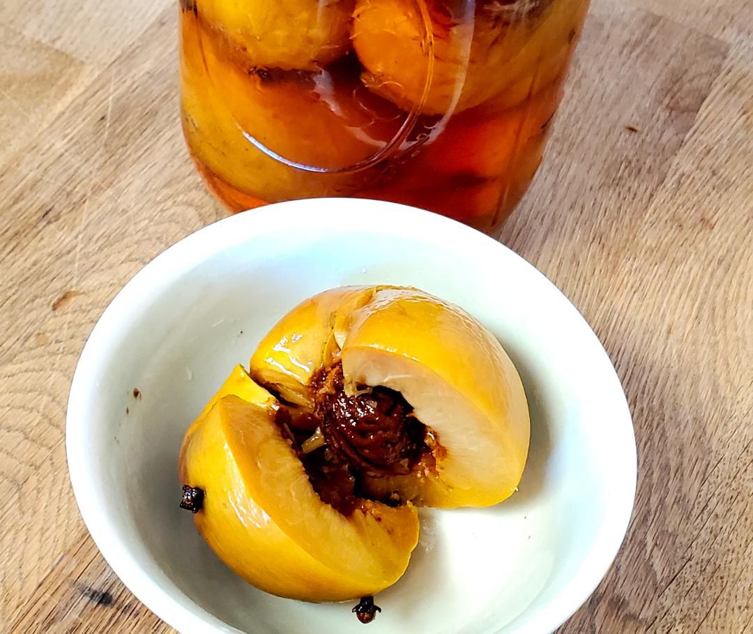 Pickled Peach in a bowl next to a jar
