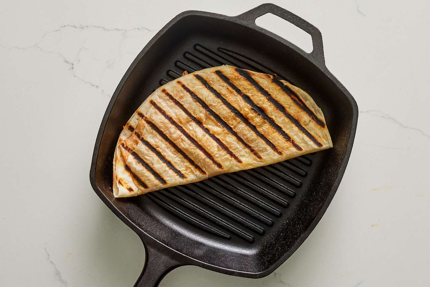 A folded quesadillas in a grill pan